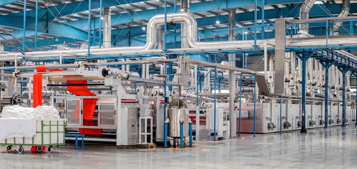 Textile fabric rolls stacked in a garment factory warehouse ready for clothing production cutting