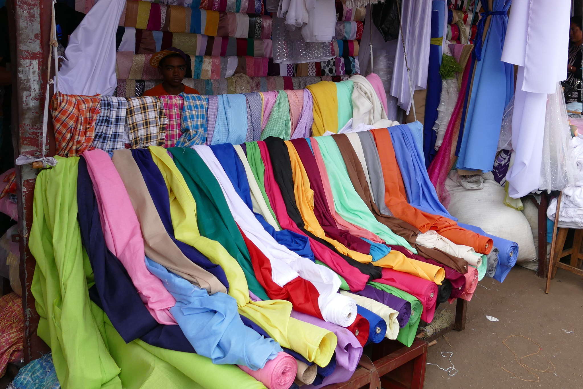 Colorful fabric rolls of cotton and polyester stacked in a textile warehouse for clothing manufacturing