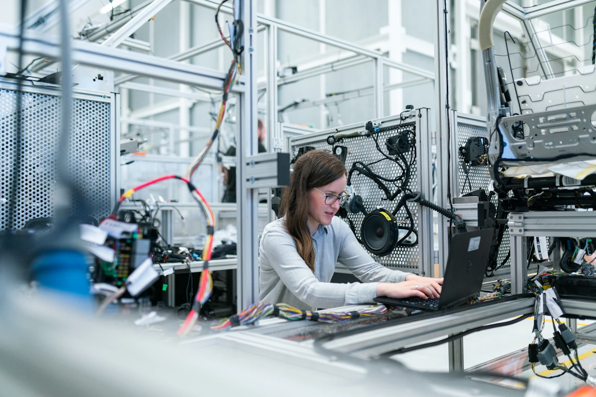 B2B quality control inspector reviewing garment specifications against tech pack at clothing manufacturer