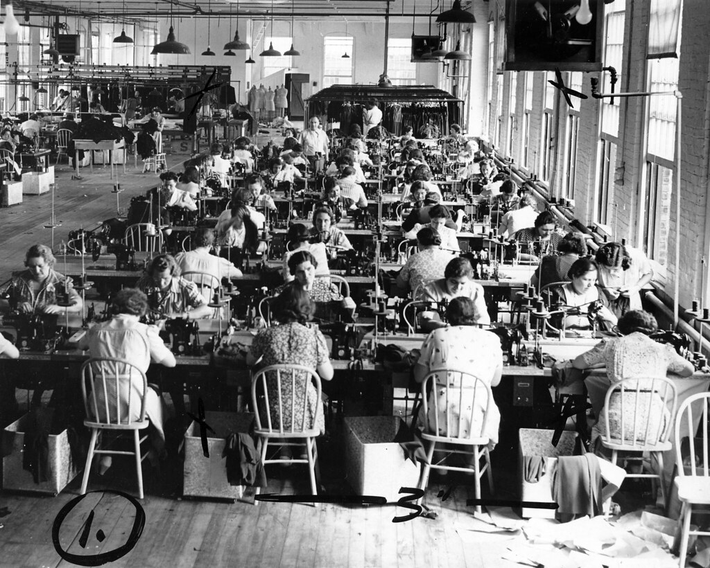 Women sewing garments at long tables in a certified factory setting