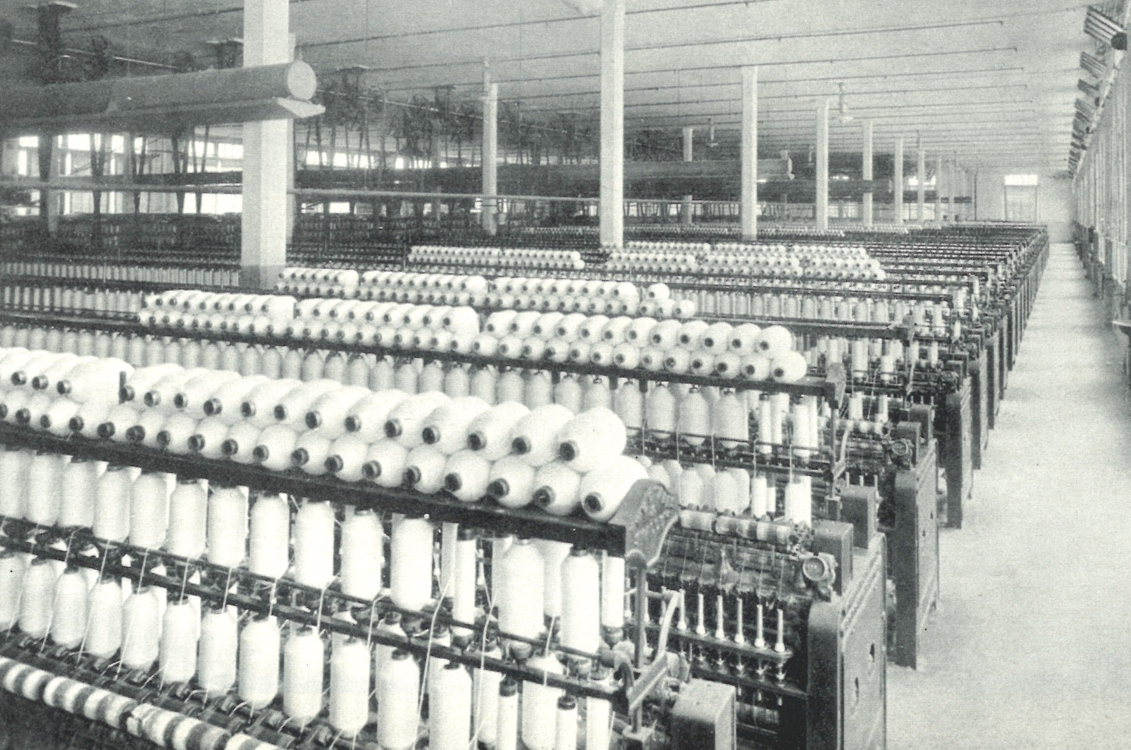 Historic spinning mill production line showing textile yarn manufacturing equipment in Italian factory setting