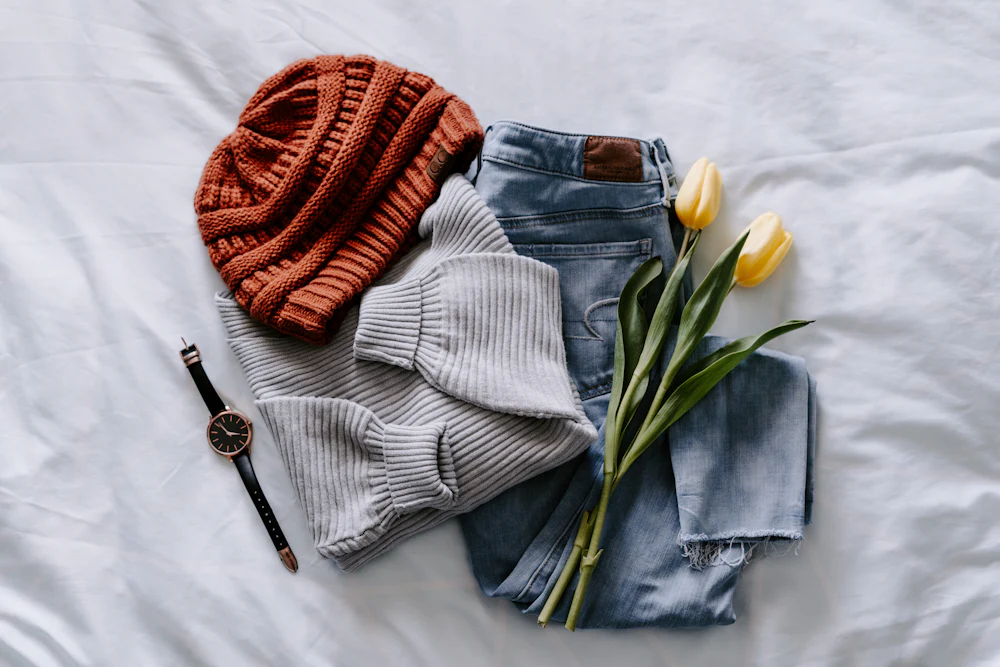 Cozy knit loungewear pieces laid flat — ribbed lounge sweater with knit beanie