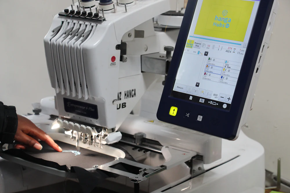 Multi-needle computerized embroidery machine stitching a logo onto fabric