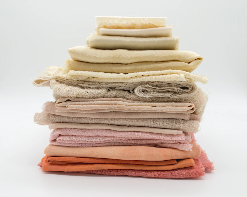 Stack of folded fabric swatches in a range of dye lots representative of materials tested for OEKO-TEX certification
