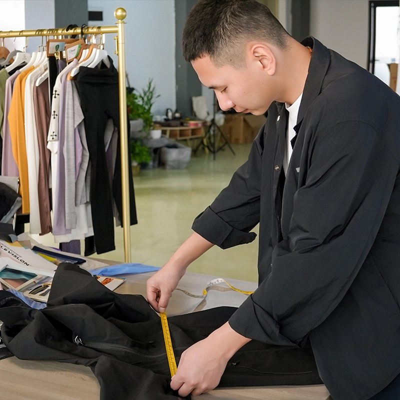 Quality control staff measuring a garment for a school uniform manufacturer order