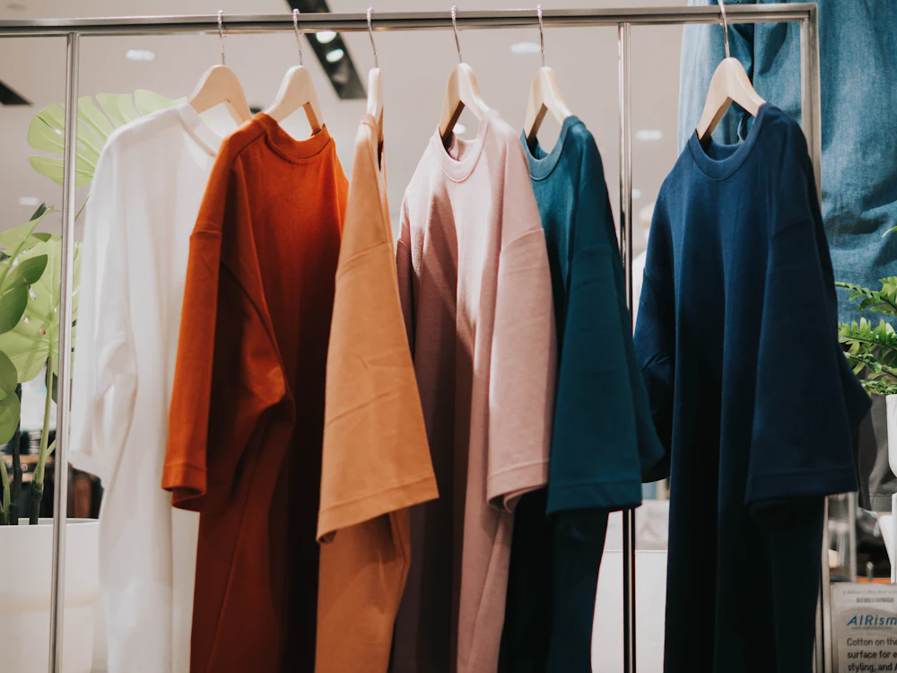 Soft cotton loungewear tops in muted colorways hanging on a fabric selection rack
