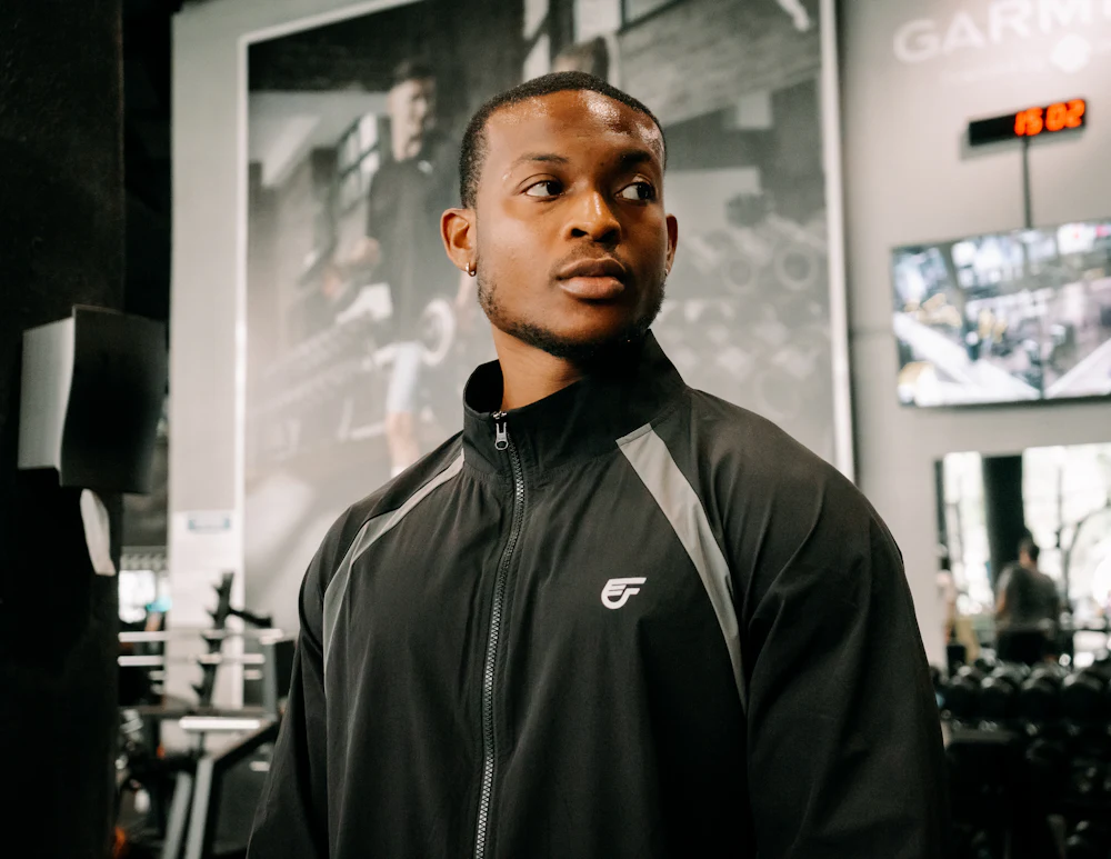 Raglan-sleeve track jacket manufacturer sample with front zip closure worn in a training facility