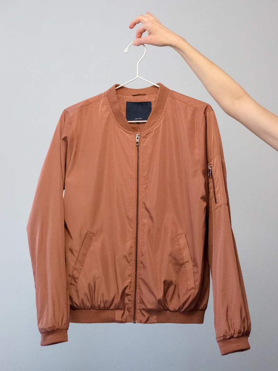 Ribbed collar and cuff construction on a bomber jacket, the comparison silhouette to a track jacket manufacturer's lighter shell build