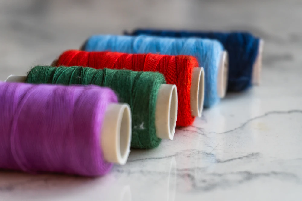 Colorful polyester and rayon thread spools used by a woven label manufacturer to weave custom brand labels
