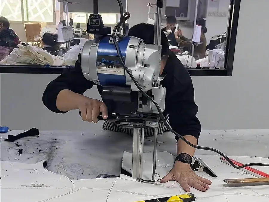 Straight-knife cutter following a graded marker layout at PRP Apparel's Dongguan factory