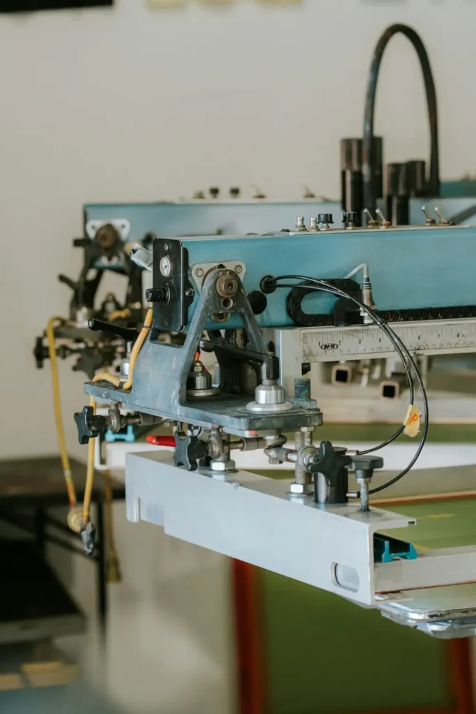 Screen printing press with mesh screen loaded, showing the physical setup behind spot-color separation