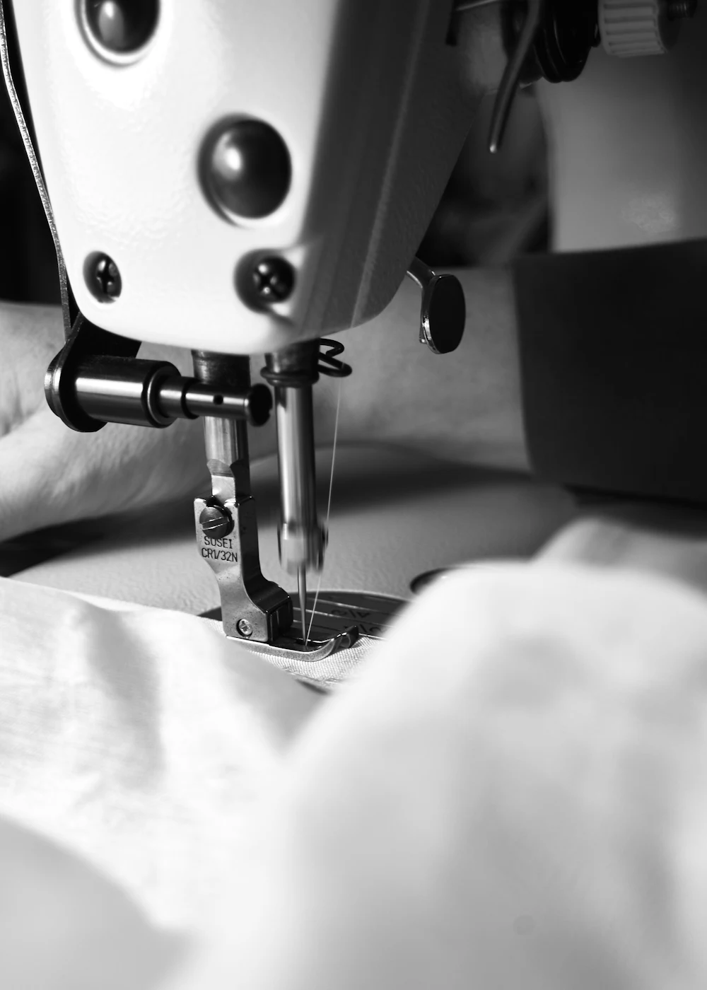 Industrial sewing machine stitching fabric seam at a bralette manufacturer