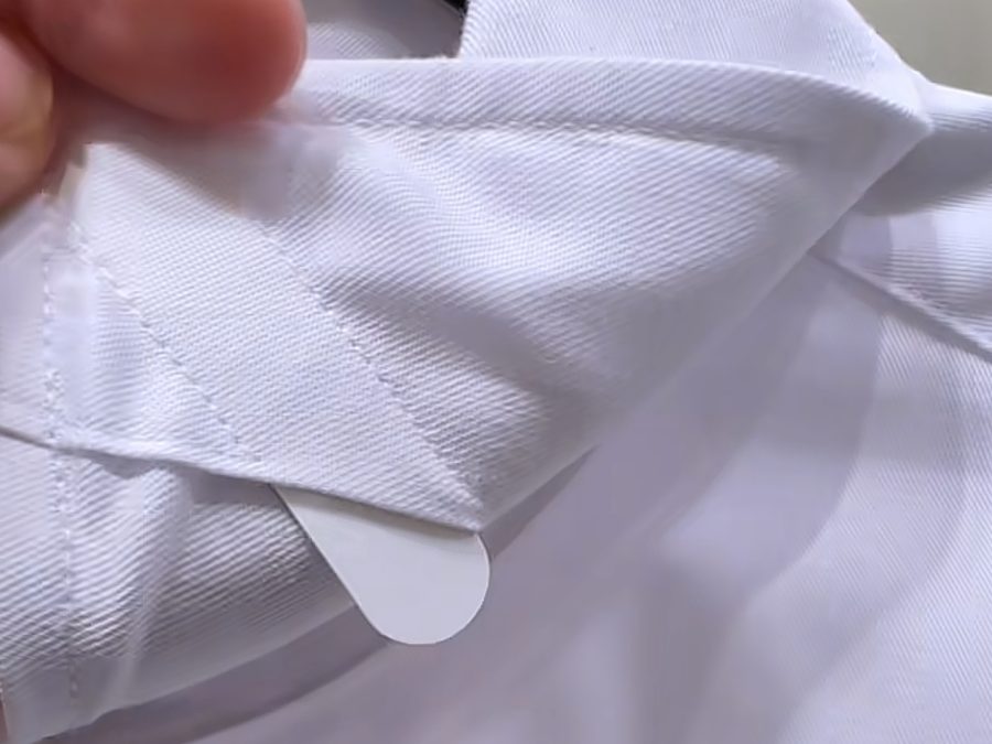 Quality control check of a corporate uniform shirt collar seam