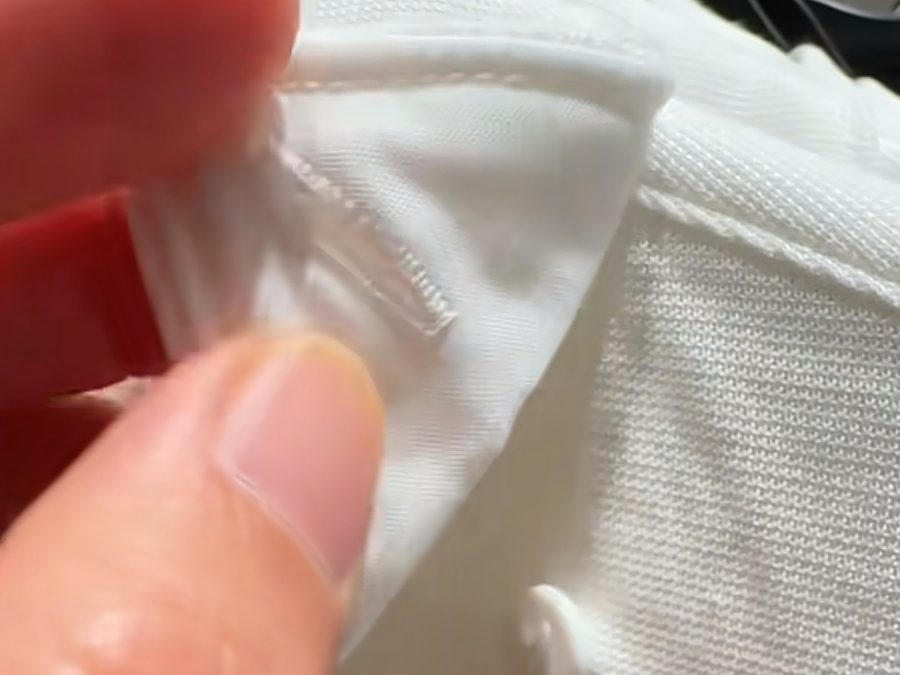 Quality control check of a corporate uniform shirt cuff stitch