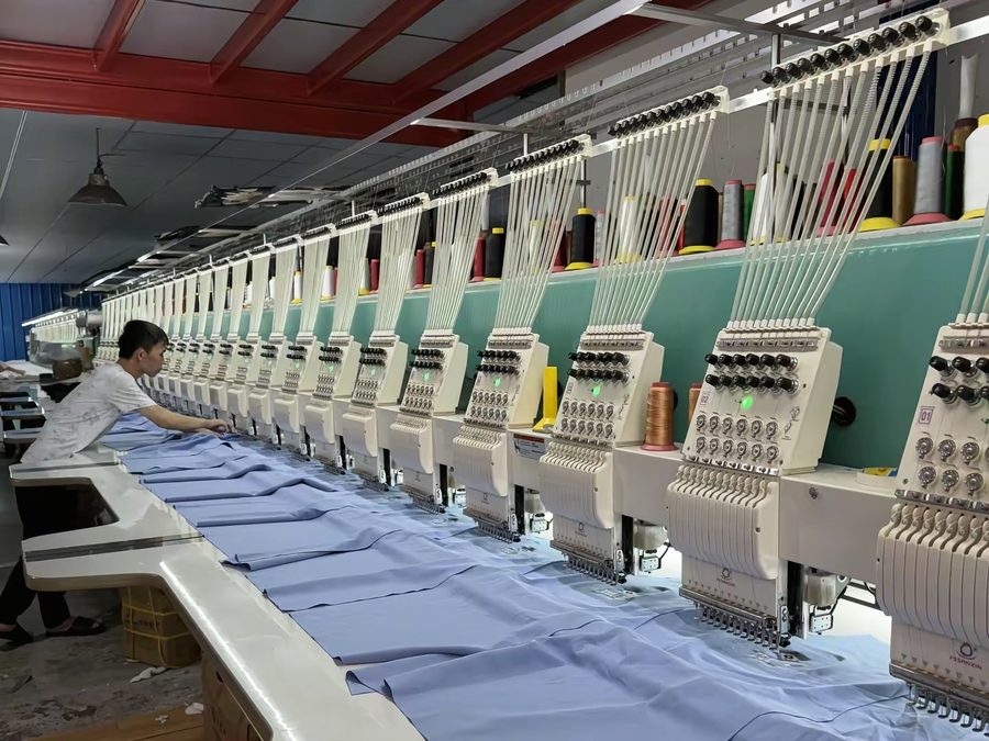 Multi-head embroidery machines running custom embroidery during clothing manufacturing