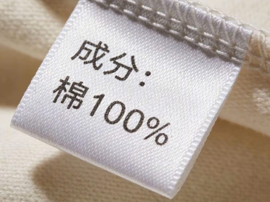Close-up of a woven fabric composition label reading 100 percent cotton