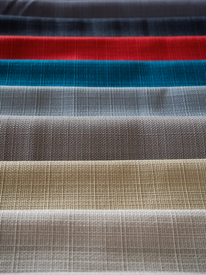 Woven fabric swatches in a row, used for fabric shrinkage testing before bulk cutting