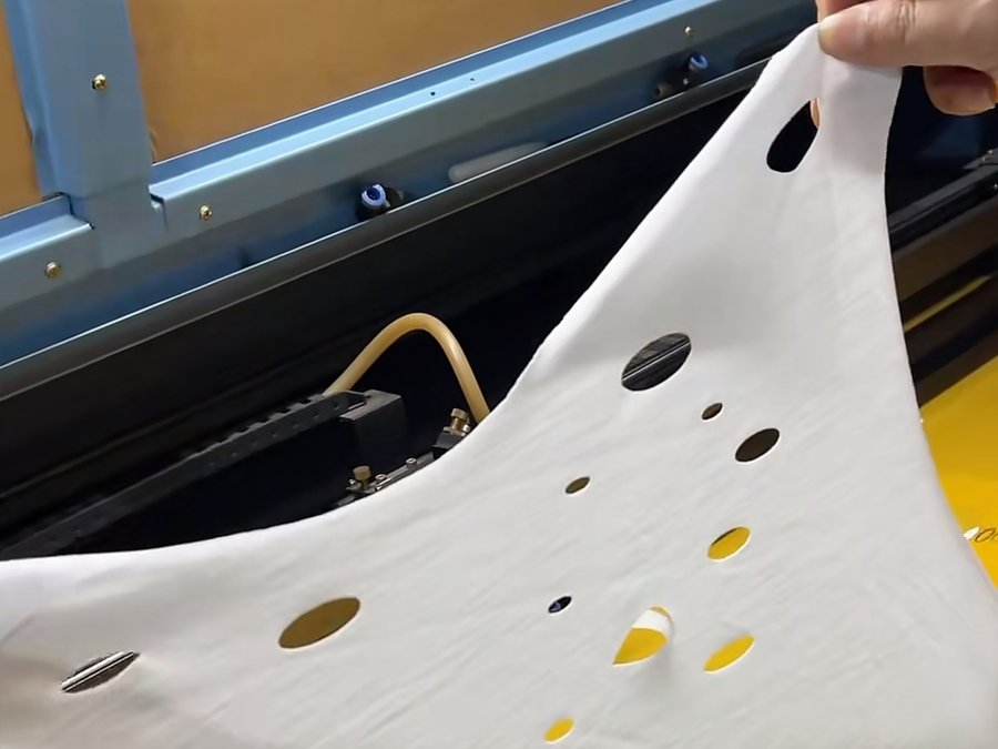 Laser-cut eyelet detail work on a lightweight cotton panel for a fashion brand clothing manufacturer