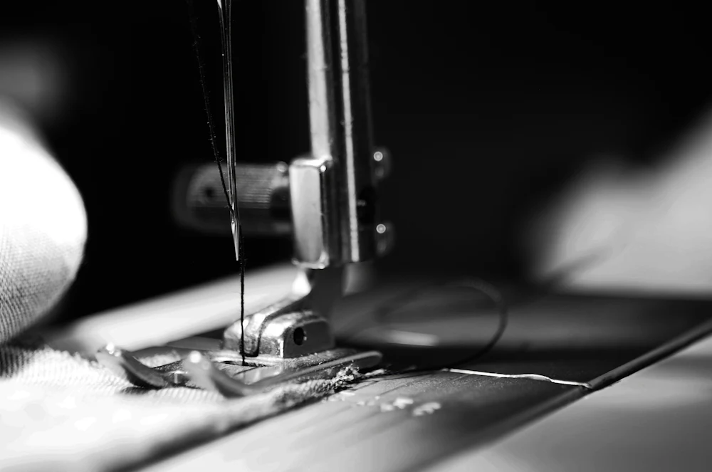 Sewing machine stitching a waistband seam on knit brief and trunk construction