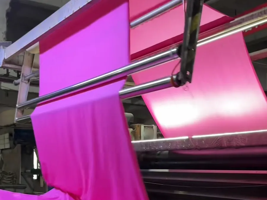 Dyed knit fabric running off the machine after bulk dyeing to an approved lab dip standard