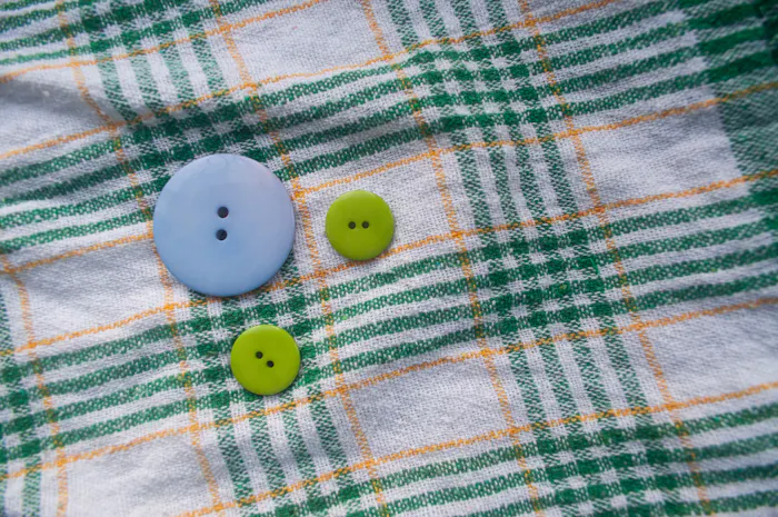Checkered flannel fabric and shell buttons used in sleep shirt button-front construction