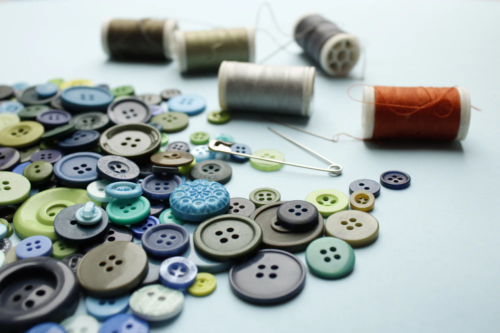Assorted buttons and thread spools representing the small-hardware side of trims sourcing for clothing manufacturers
