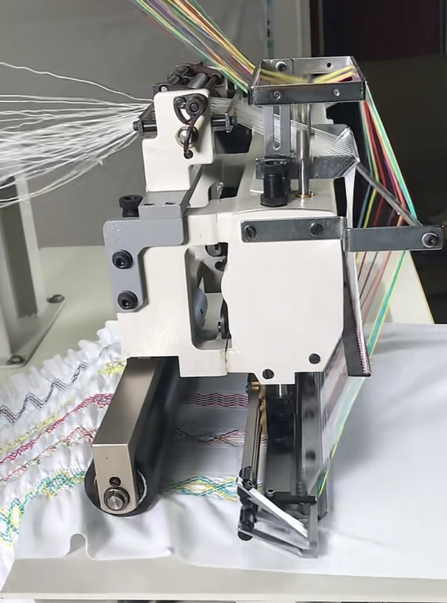 Multi-head embroidery machine stitching head with multicolored thread feeds running on white fabric